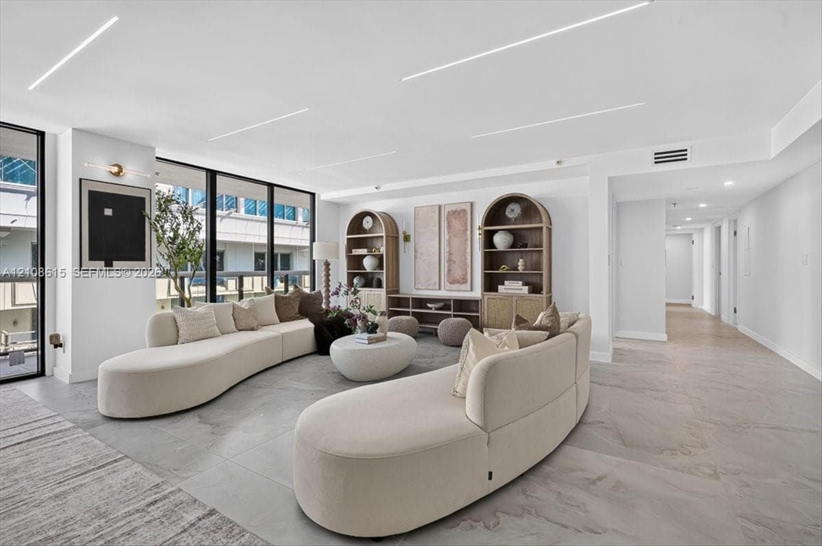 Open-concept interior featuring large-format tile flooring, floor-to-ceiling windows, and recessed linear LED lighting