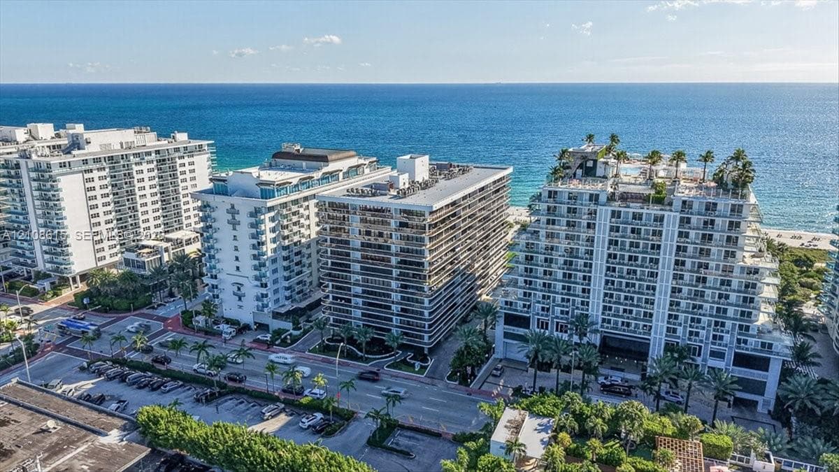 Multi-story coastal residential complex featuring private balconies, rooftop landscaping, and direct access to the beach