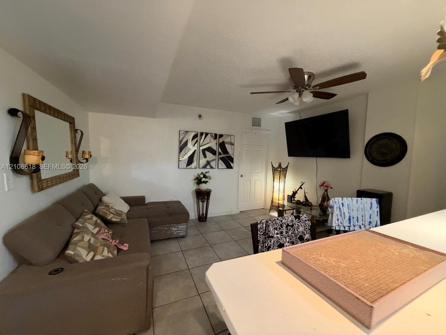 Large-format tile flooring, ceiling fan with integrated lighting, and white interior doors