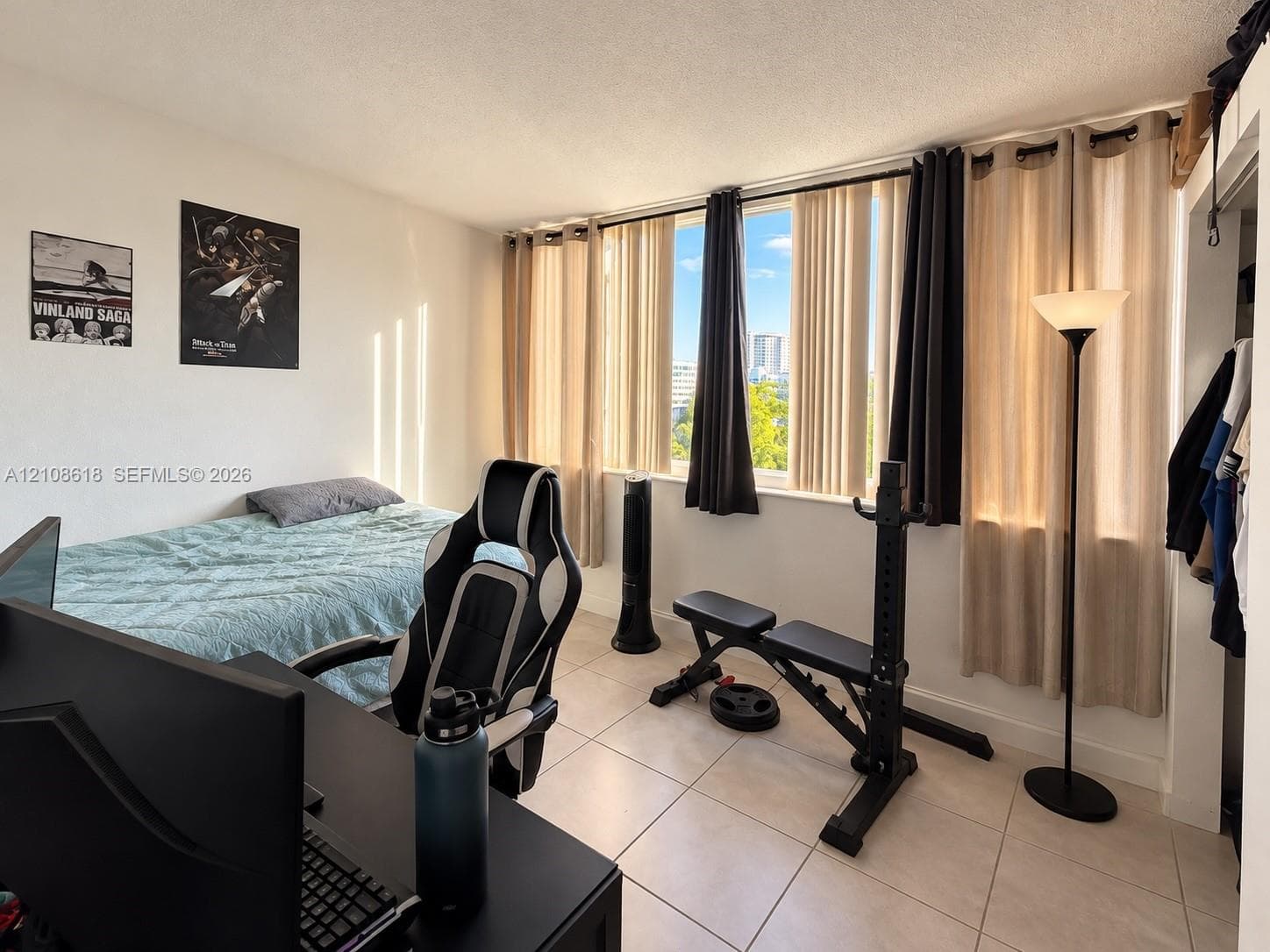 Room featuring large, floor-to-ceiling windows, ceramic tile flooring, and a built-in closet