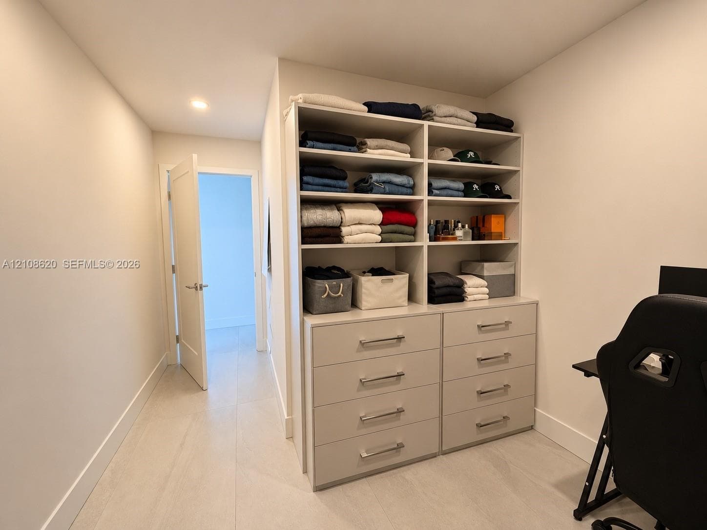 Custom built-in storage unit featuring floor-to-ceiling shelving, ten integrated soft-close drawers, and brushed metal hardware
