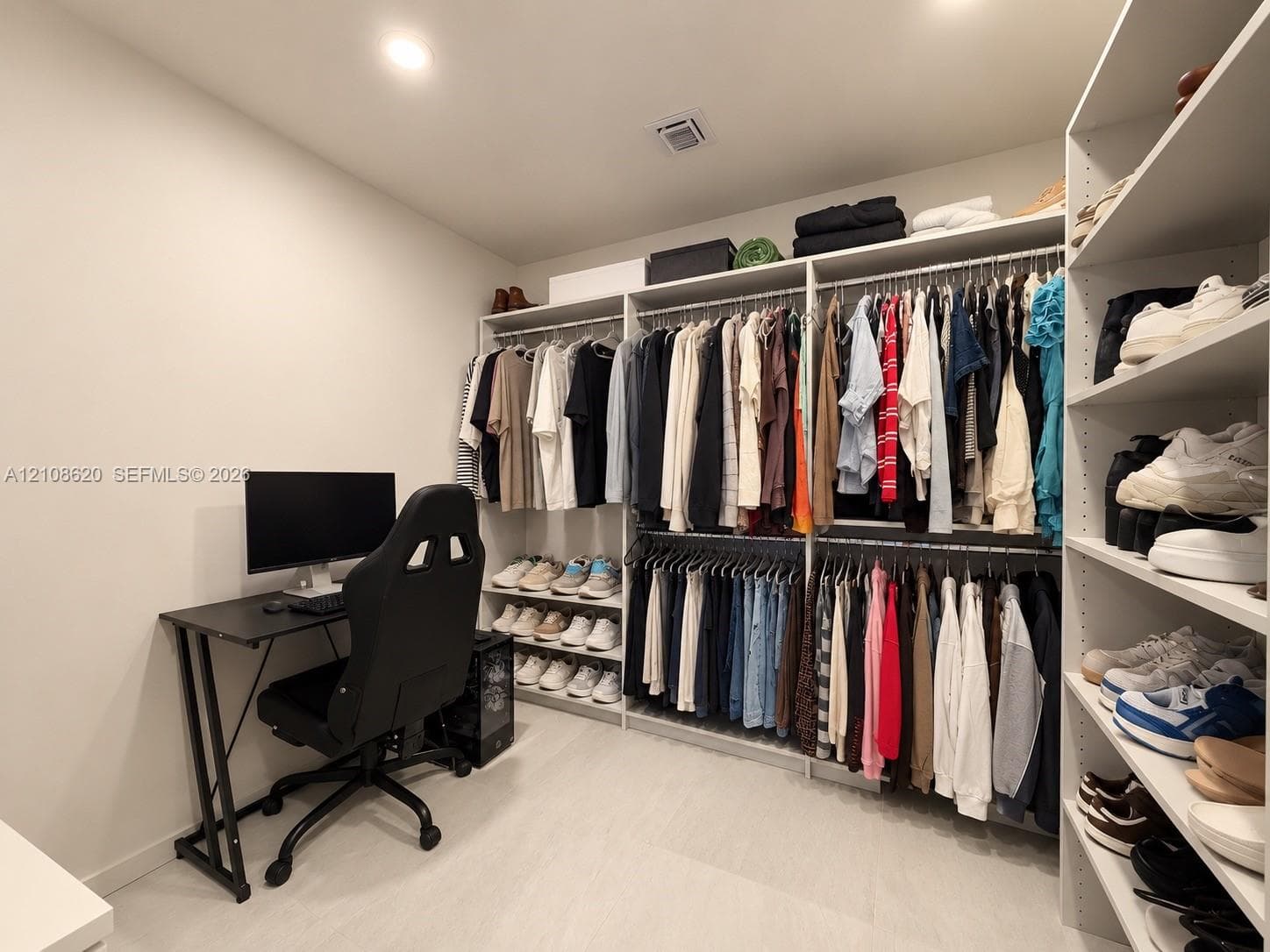 Built-in closet system featuring multi-level hanging rods and floor-to-ceiling adjustable shelving