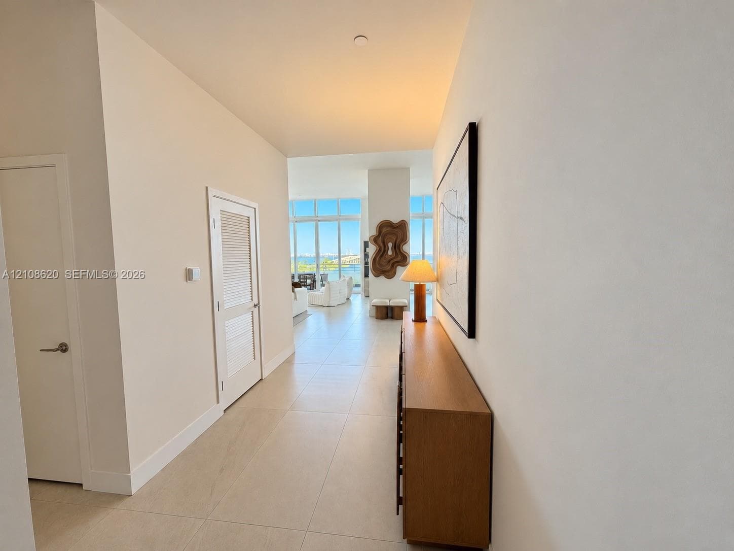Hallway featuring large-format tile flooring, high ceilings, and floor-to-ceiling windows