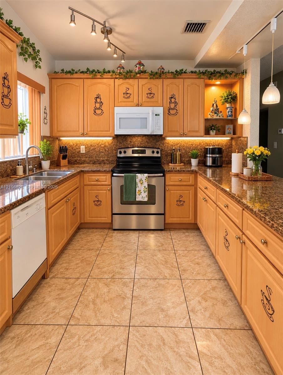 Kitchen featuring light-finish cabinetry, stone-texture countertops, tile flooring, stainless steel appliances, and adjustable track lighting