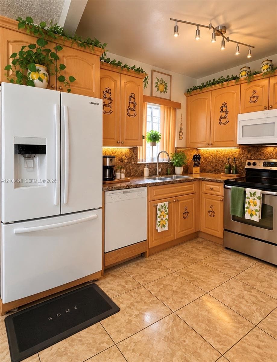 Kitchen featuring wood cabinetry, stone-finish countertops, stainless steel range, white French-door refrigerator, and under-cabinet lighting