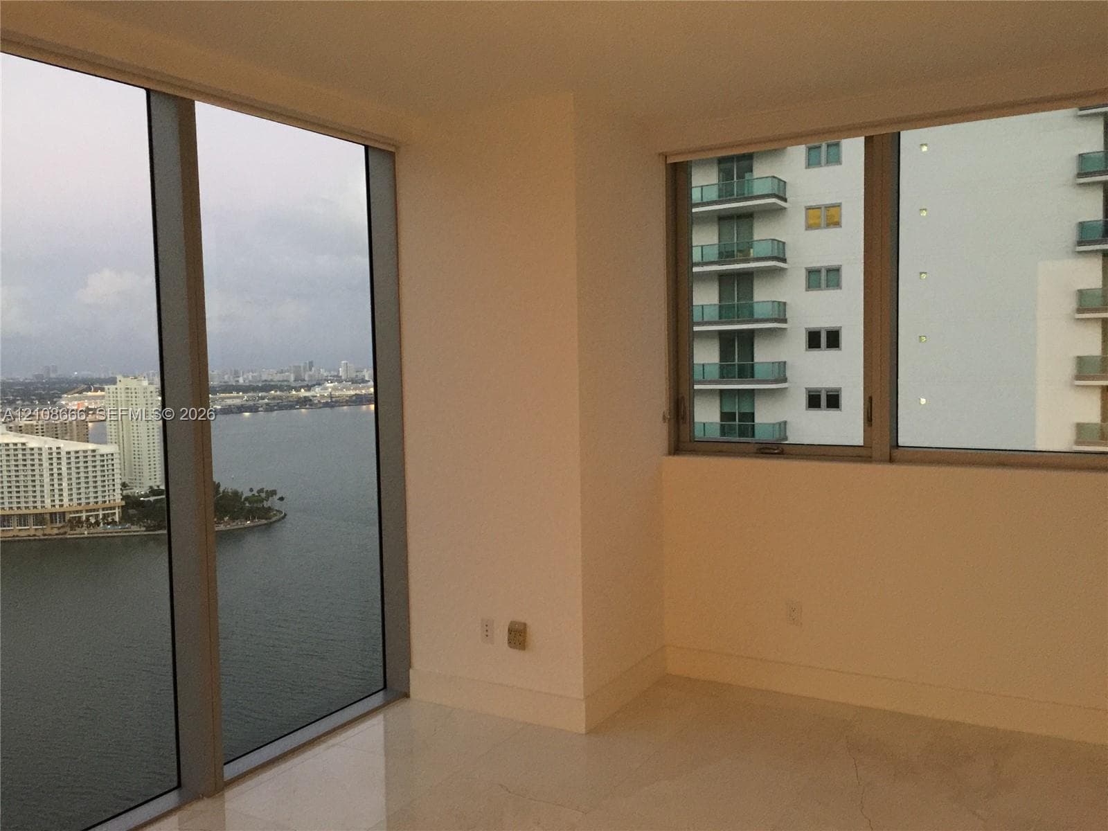 Floor-to-ceiling windows with metal framing, expansive water exposure, and light-toned flooring