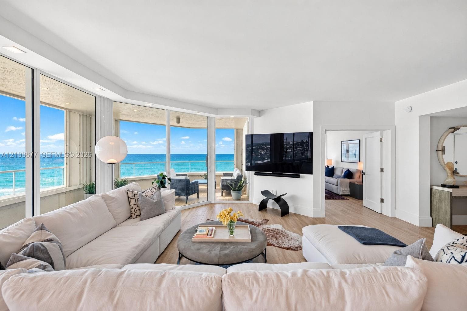 Floor-to-ceiling windows, wood look plank porcelain flooring, recessed lighting, and a private covered balcony. TV wall was expanded to accommodate a larger TV. Light filtering remote operated shades with Bandalux in curtain pocket