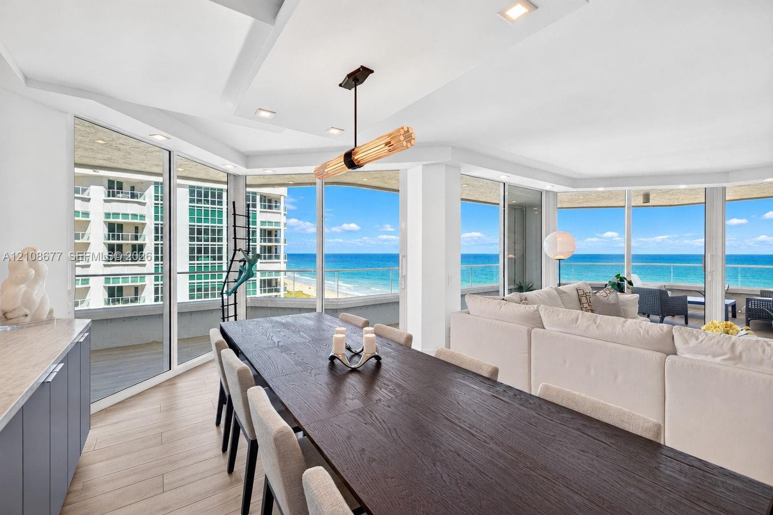 Floor-to-ceiling impact windows, wide-plank tile flooring, recessed lighting, contemporary linear light fixture, and wrap-around exterior balcony with glass railing for endless ocean views from your large formal dining area. Light filtering remote operated shades with Bandalux