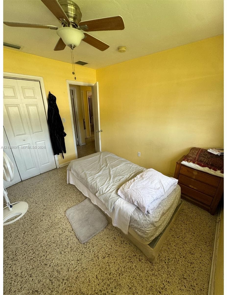 Interior space featuring terrazzo flooring, ceiling-mounted fan with integrated lighting, and dual-panel closet doors