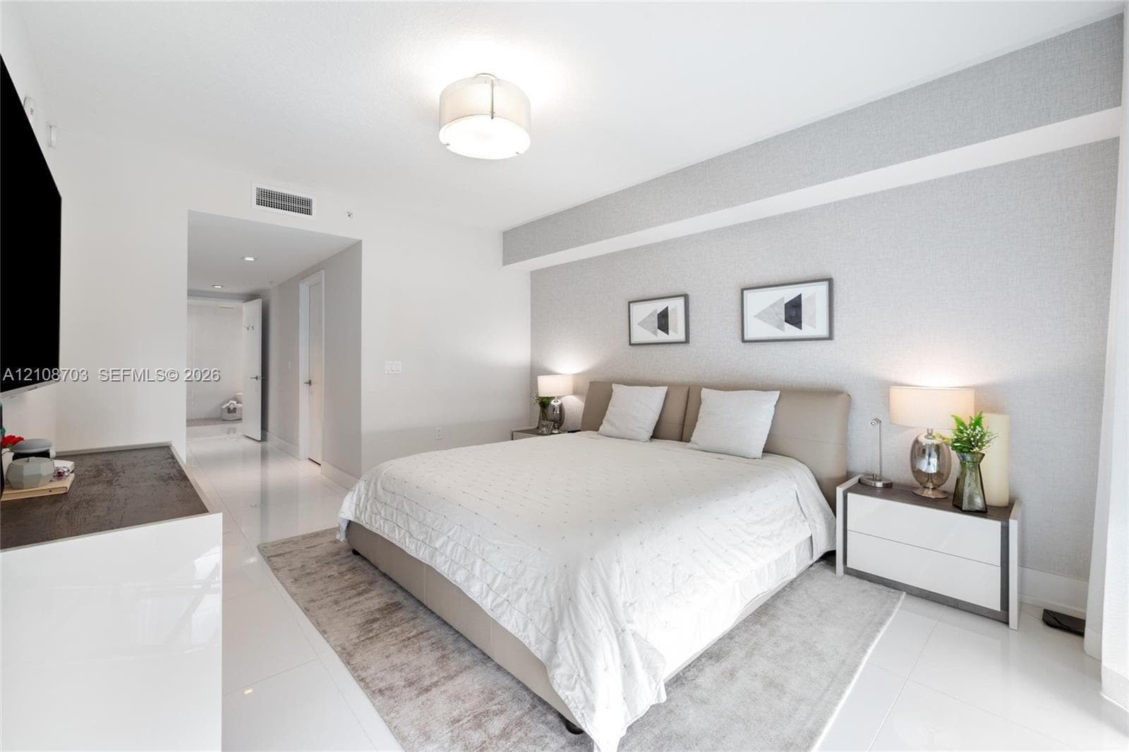 Neutral-toned textured accent wall, polished light-colored flooring, minimalist drum-style ceiling light fixture, and recessed lighting