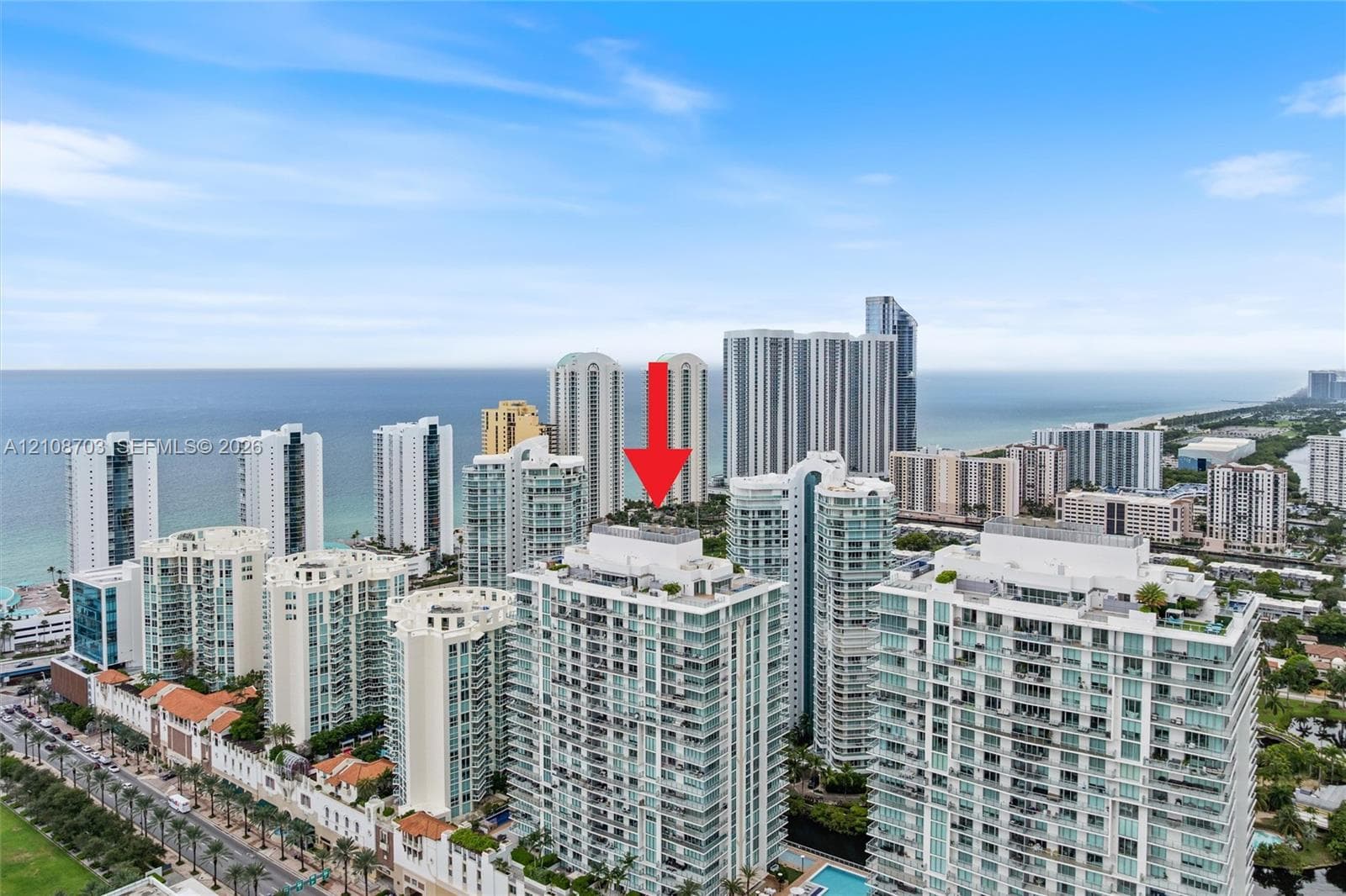 High-rise residential building featuring expansive glass balconies and coastal surroundings