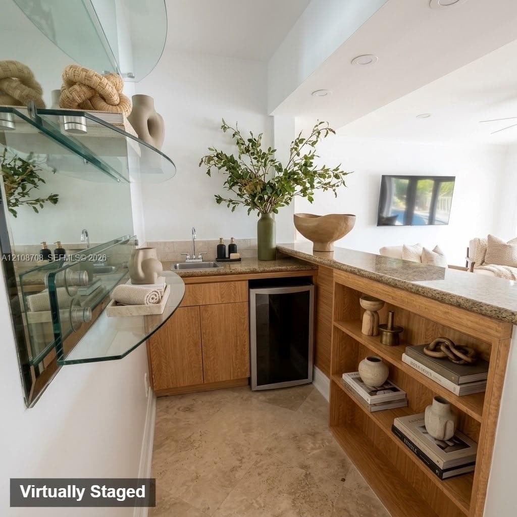 Wet bar featuring wood cabinetry, stone countertops, built-in shelving, an under-counter beverage refrigerator, and floating glass wall shelving