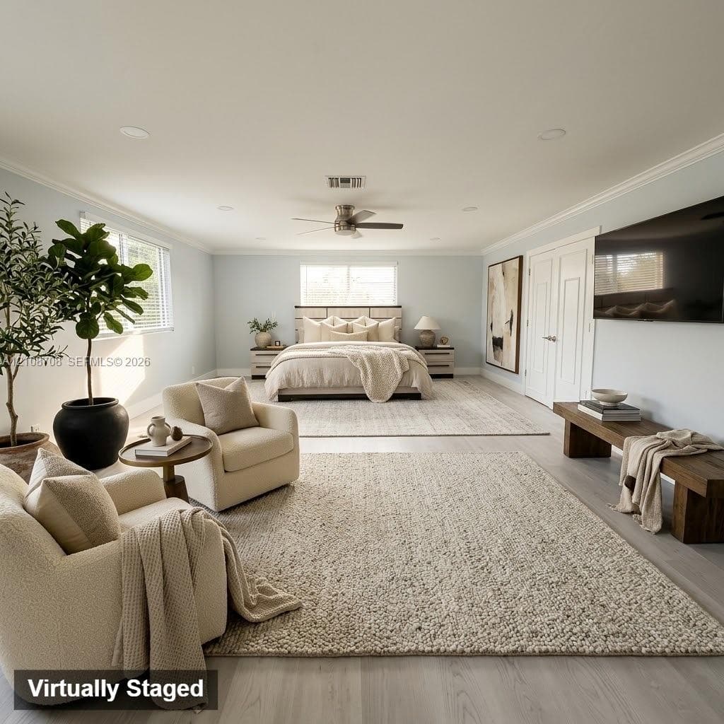 Expansive room featuring wood-finish flooring, recessed lighting, double-door closet entry, multi-blade ceiling fan, and large windows