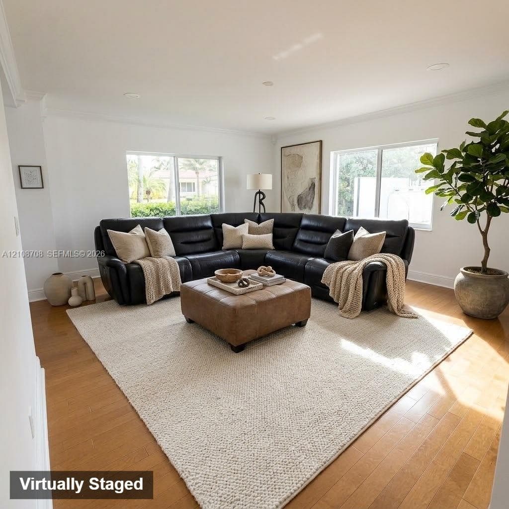 Living area featuring wood-finish flooring, recessed lighting, crown molding, and large windows with natural light