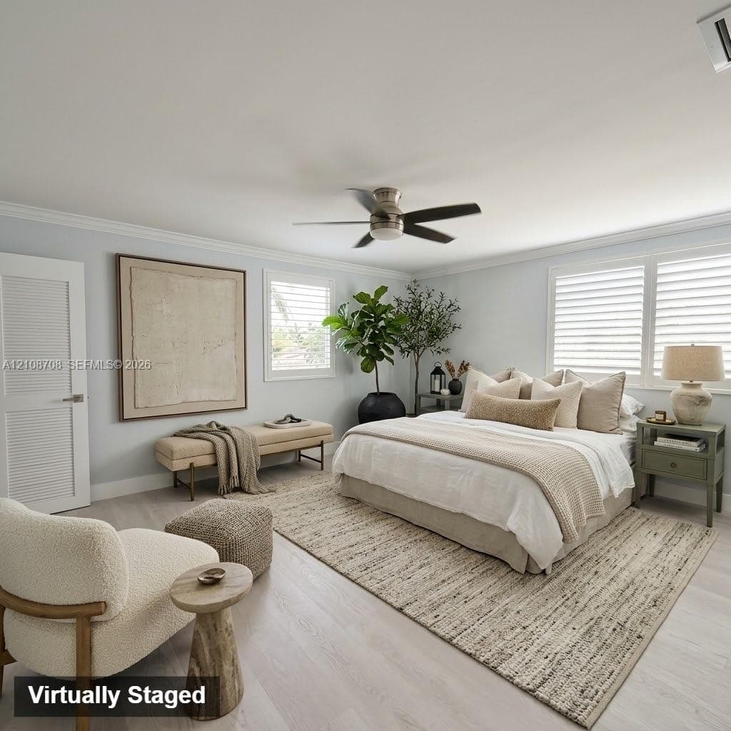 Neutral tone interior featuring wood-finish flooring, crown molding, louvered closet door, multi-blade ceiling fan with integrated lighting, and plantation shutters