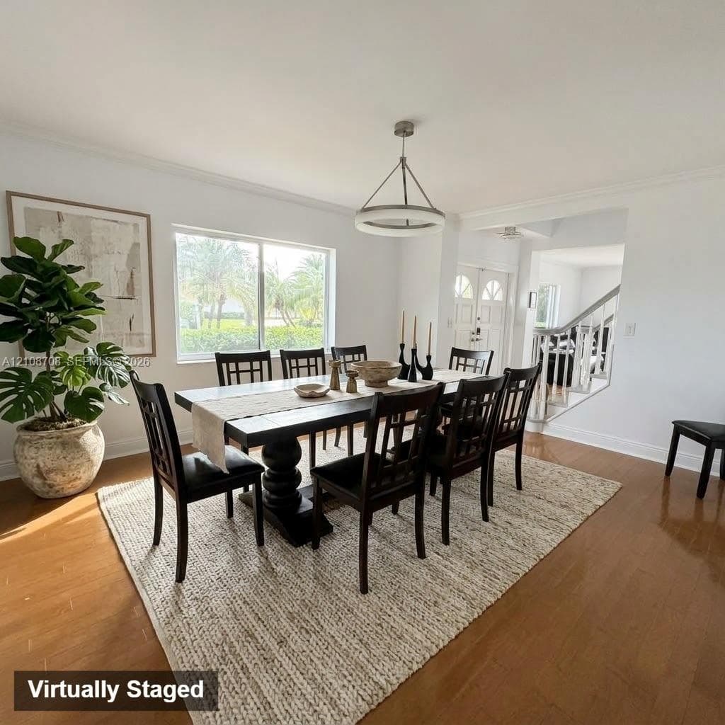 Hardwood flooring, crown molding, circular tiered chandelier, and a large horizontal sliding window