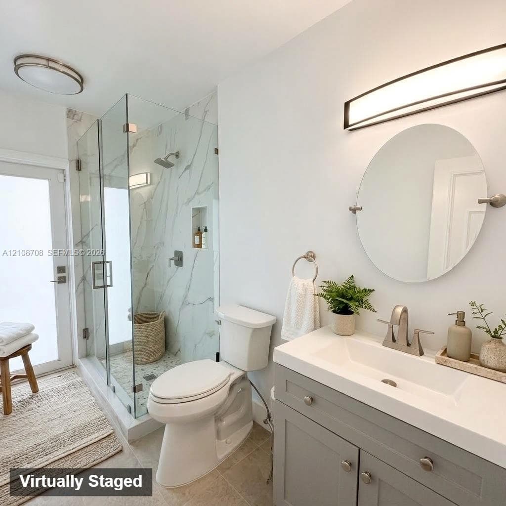 Glass-enclosed shower with full-height stone-patterned wall surround and integrated storage niche, vanity cabinet with integrated rectangular sink, wall-mounted oval mirror, and contemporary light fixtures