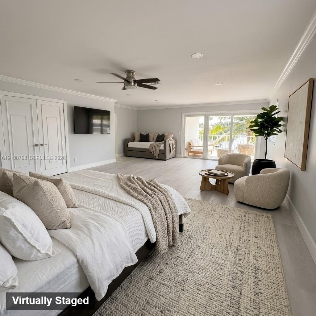 Interior space featuring light wood-finish flooring, recessed lighting, a brushed nickel ceiling fan, double-panel interior doors, and floor-to-ceiling glass sliding doors opening to a covered balcony