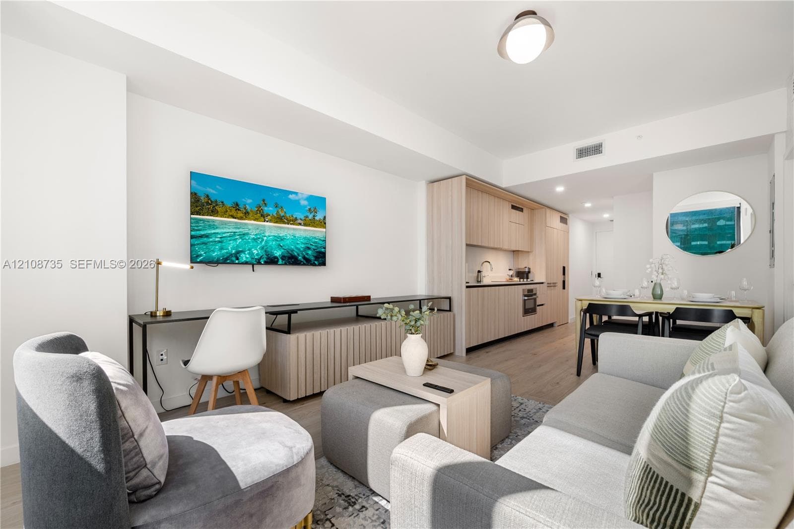 Open-concept floor plan featuring wood-finish flooring, recessed lighting, and custom light-toned cabinetry