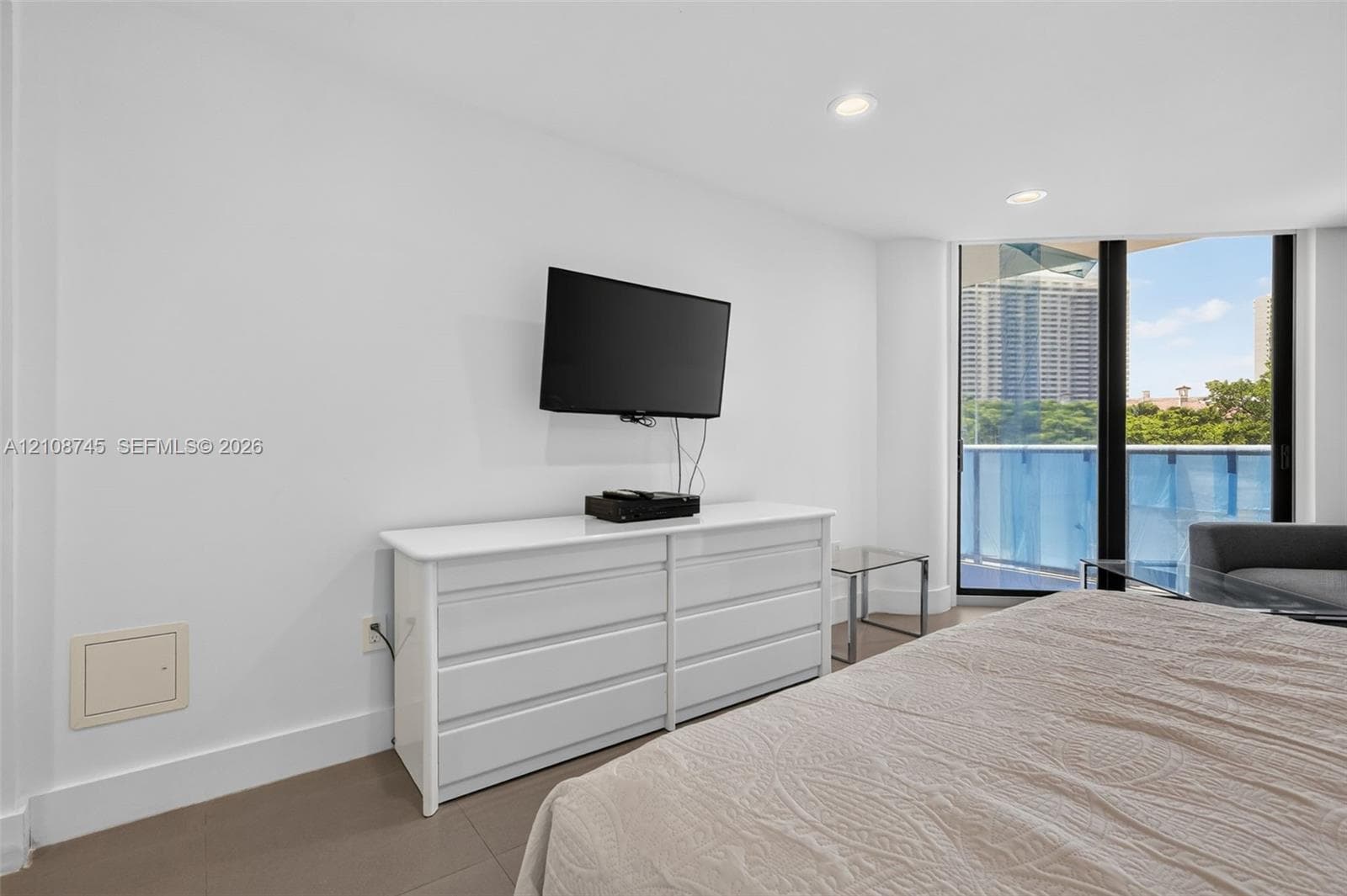 Room with recessed lighting, tile flooring, and floor-to-ceiling glass door providing outdoor access