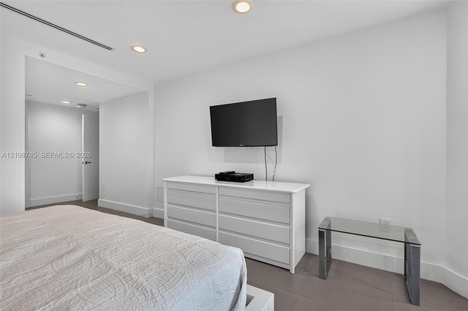 Neutral-toned ceramic flooring, recessed ceiling lighting, and smooth-finish walls