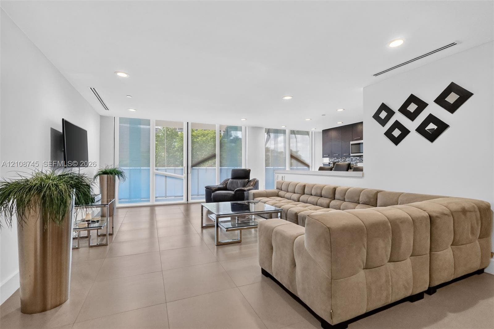 Living area featuring large-format tile flooring, recessed lighting, floor-to-ceiling windows, and linear ceiling diffusers