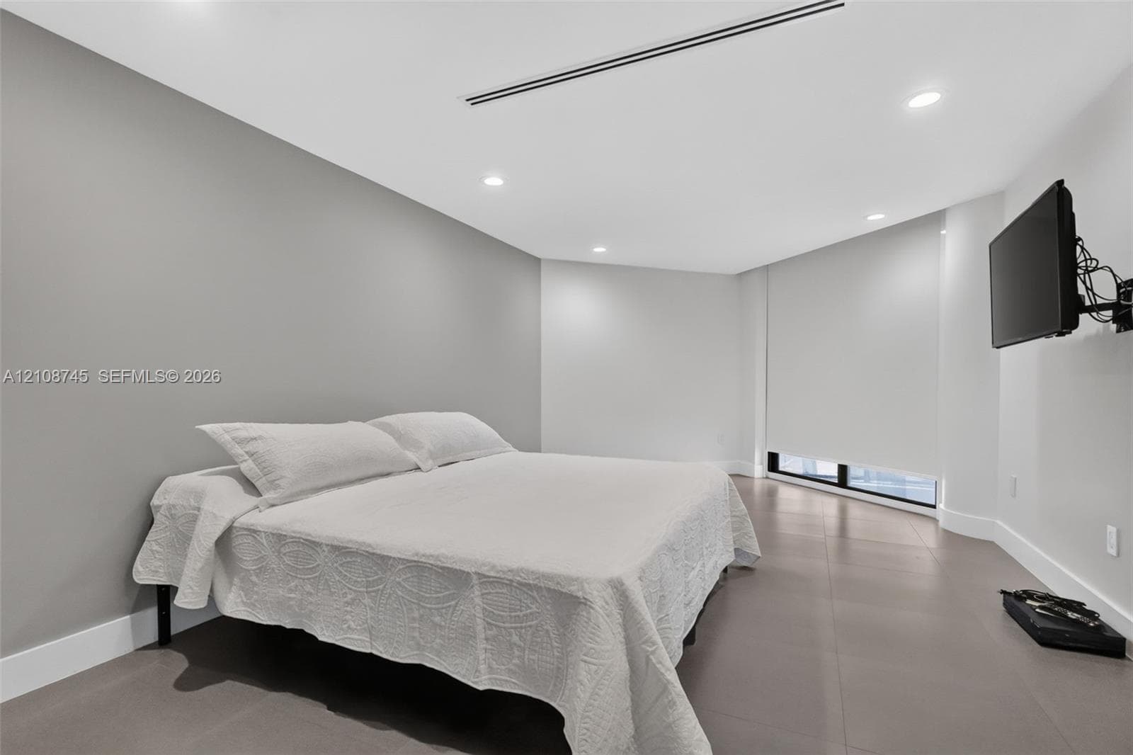 Room featuring large-format tile flooring, recessed lighting, and a linear HVAC diffuser