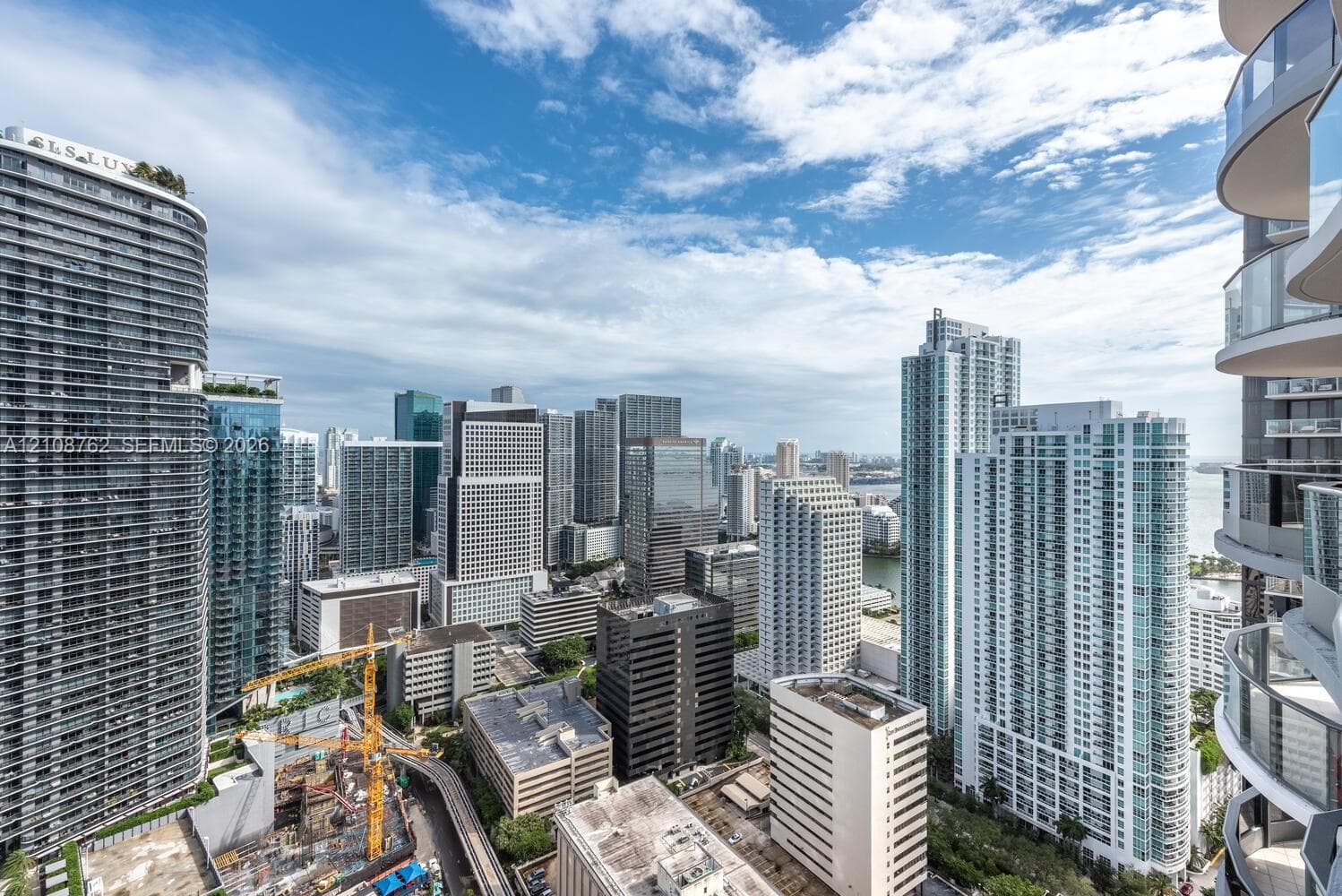 High-rise balcony featuring curved glass railings and an expansive cityscape panorama