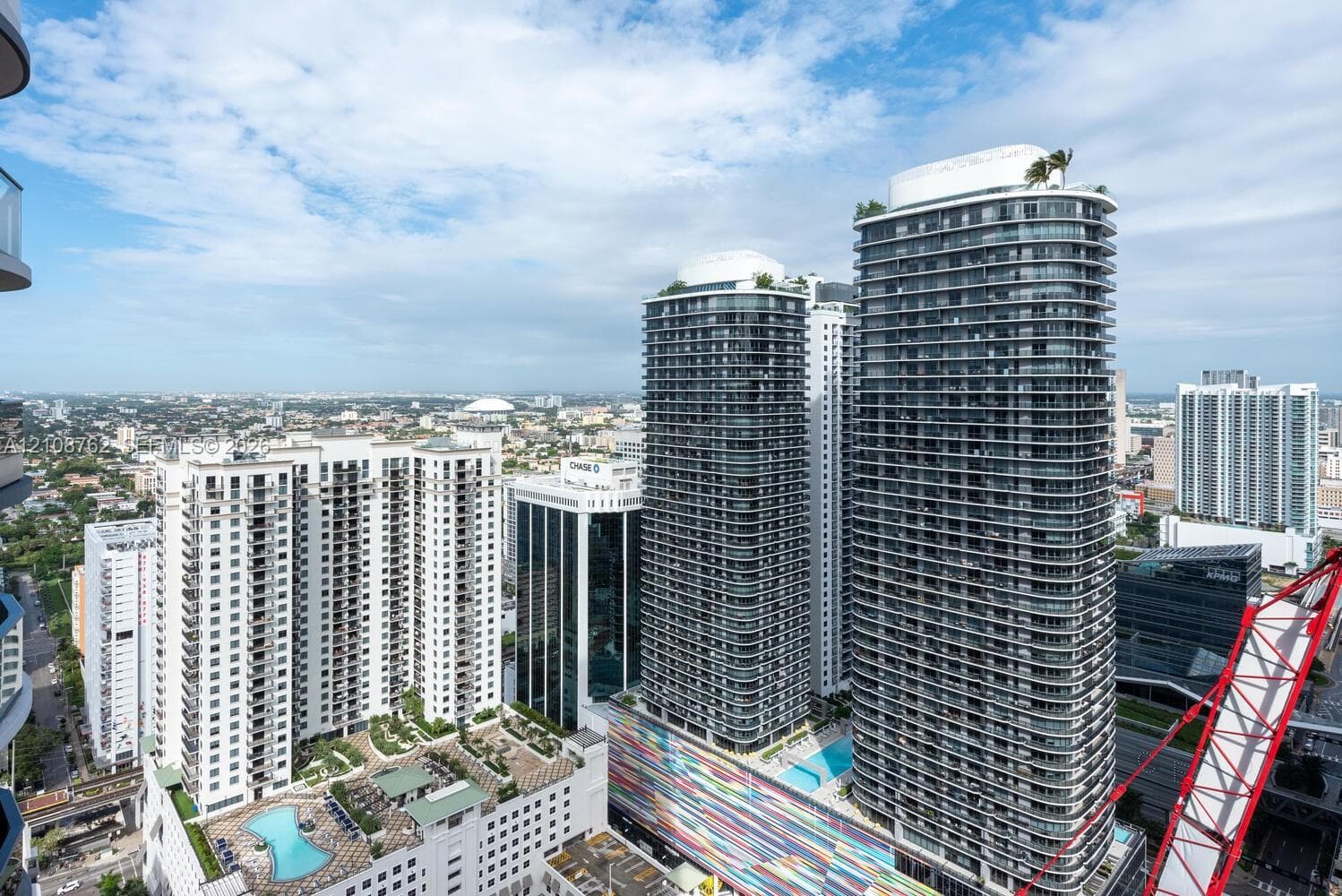 High-rise urban landscape featuring contemporary multi-story towers, architectural glass facades, rooftop amenity decks, and elevated swimming pools