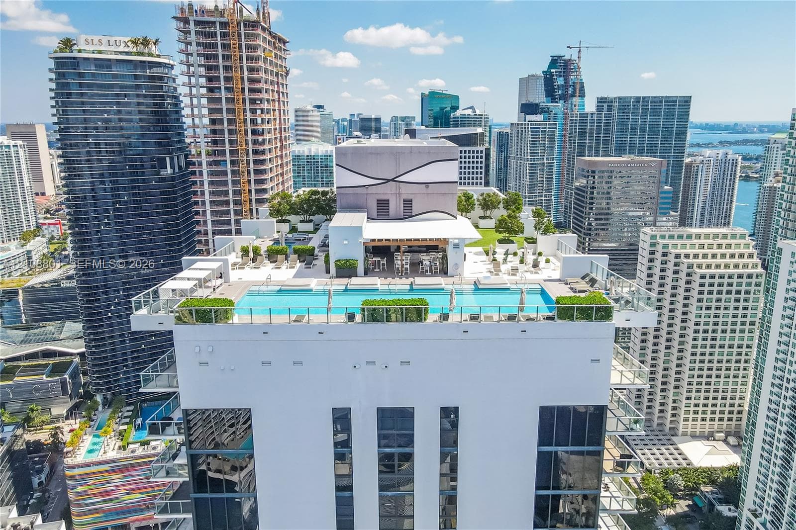 Rooftop terrace featuring an expansive swimming pool, integrated landscaping, and a covered lounge area