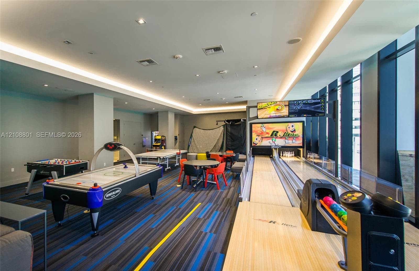 Recreation area featuring a built-in bowling lane, recessed ceiling lighting, cove lighting, and floor-to-ceiling windows