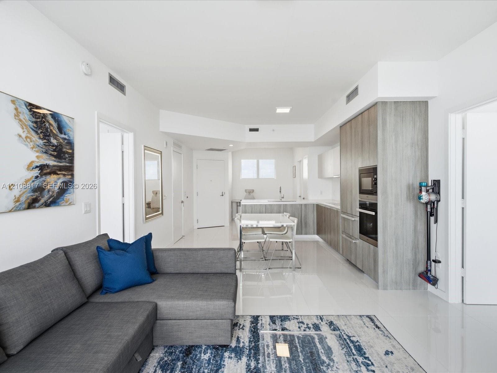Kitchen featuring wood-finish cabinetry, built-in wall oven, and smooth surface flooring