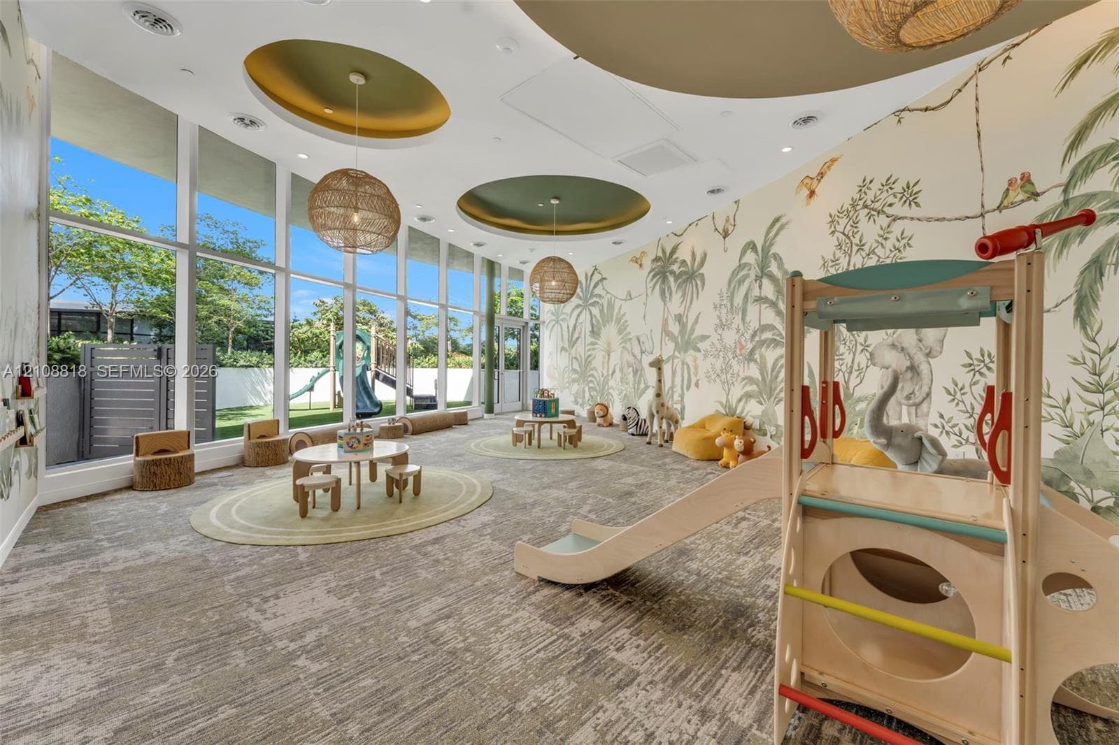 Floor-to-ceiling windows, circular recessed ceiling features with accent lighting, woven pendant light fixtures, and expansive custom wall mural