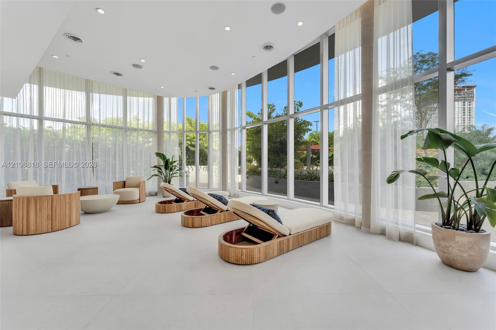 Floor-to-ceiling windows, recessed lighting, integrated ceiling speakers, and expansive tile flooring