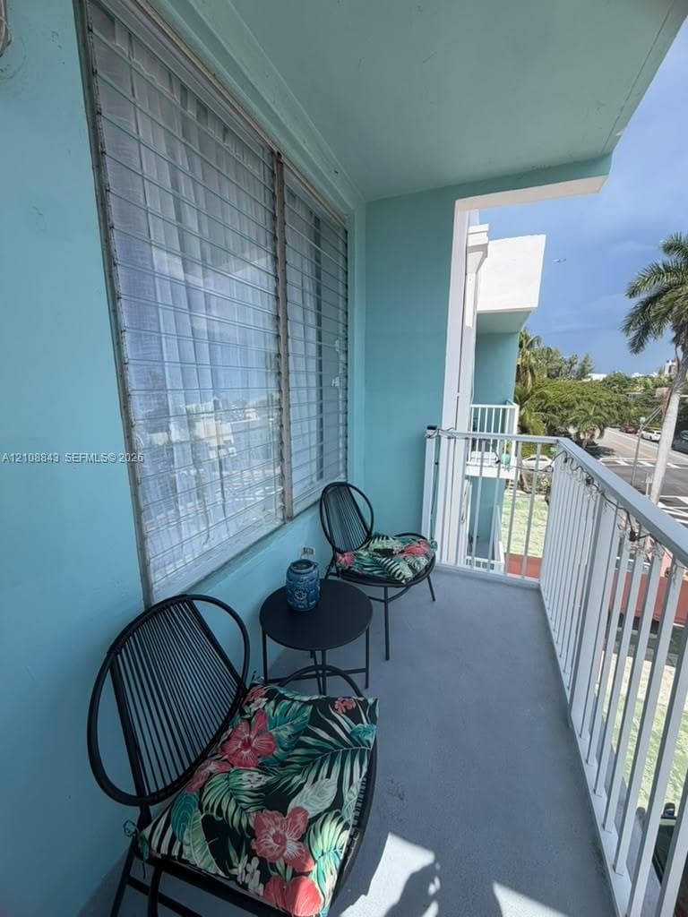 Private balcony featuring a concrete surface, metal railing, and aluminum-frame window system