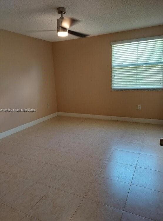 Room featuring neutral-toned tile flooring, light-colored walls, a ceiling fan with integrated light, and a window with horizontal blinds