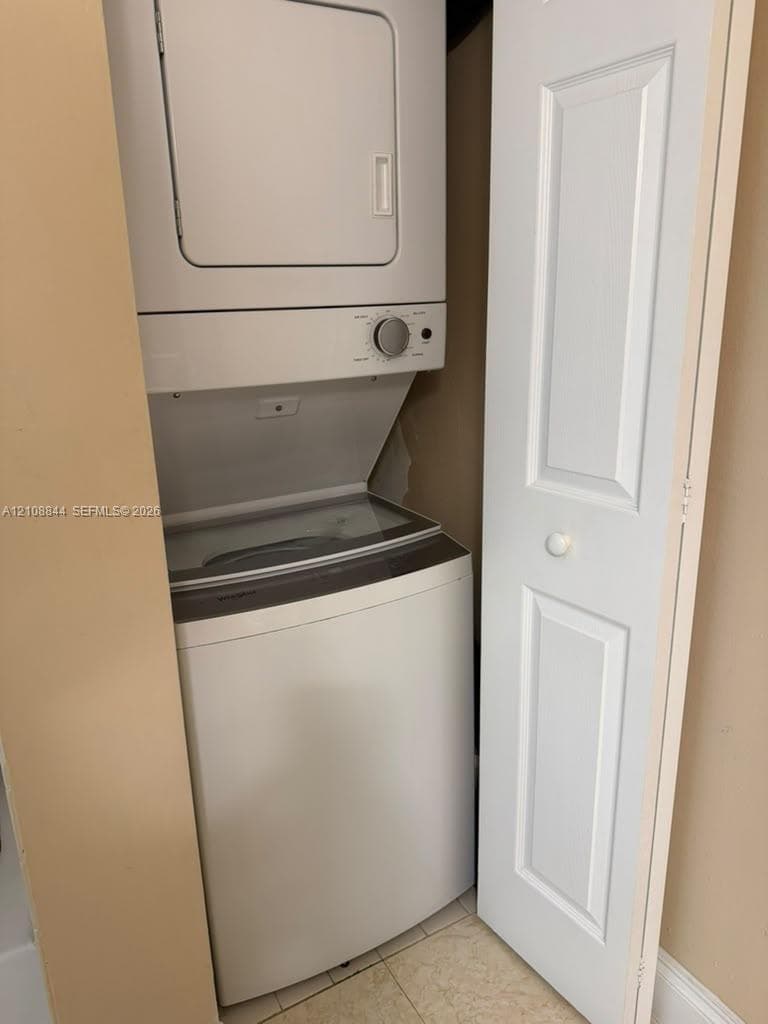 Stacked laundry center with high-efficiency white appliance finish and multi-panel interior door