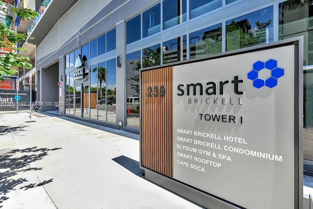 Modern building exterior featuring floor-to-ceiling glass windows, architectural wood-slat accents, and integrated signage
