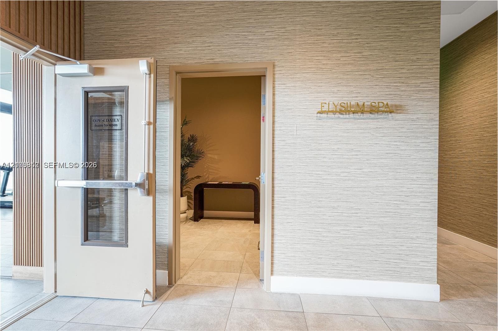 Textured wall coverings, vertical wood-slat paneling, neutral tile flooring, and metallic signage
