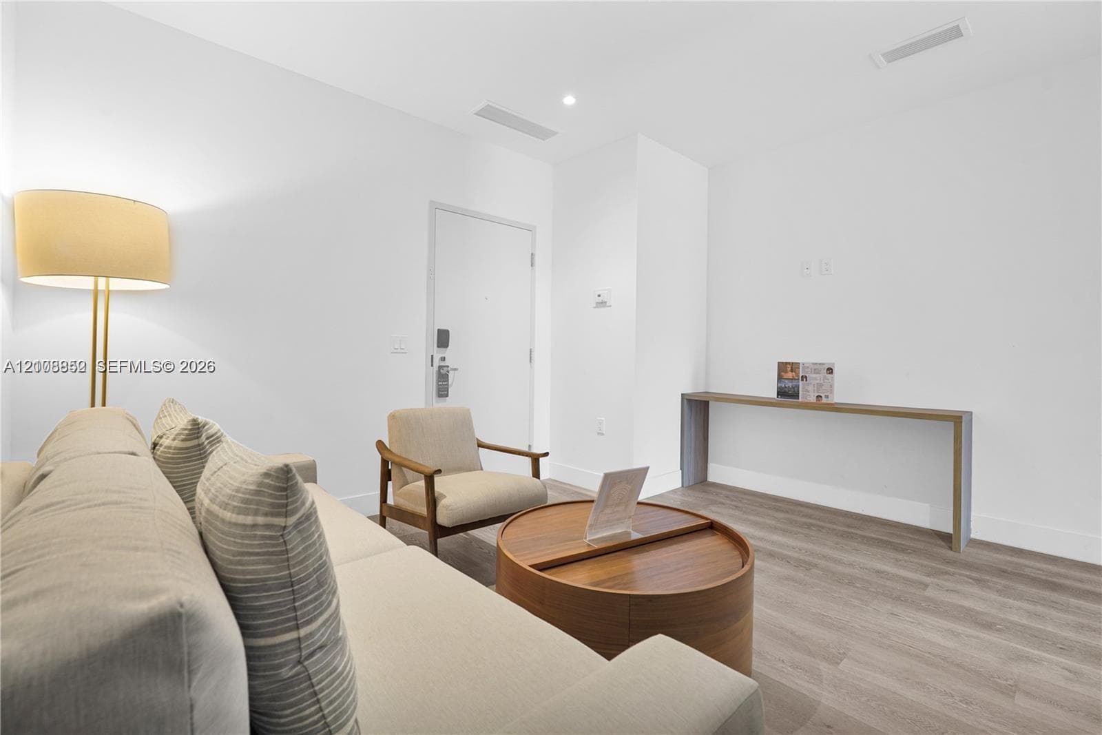 Neutral interior space featuring wood-finish flooring, recessed lighting, and a built-in wall-mounted console