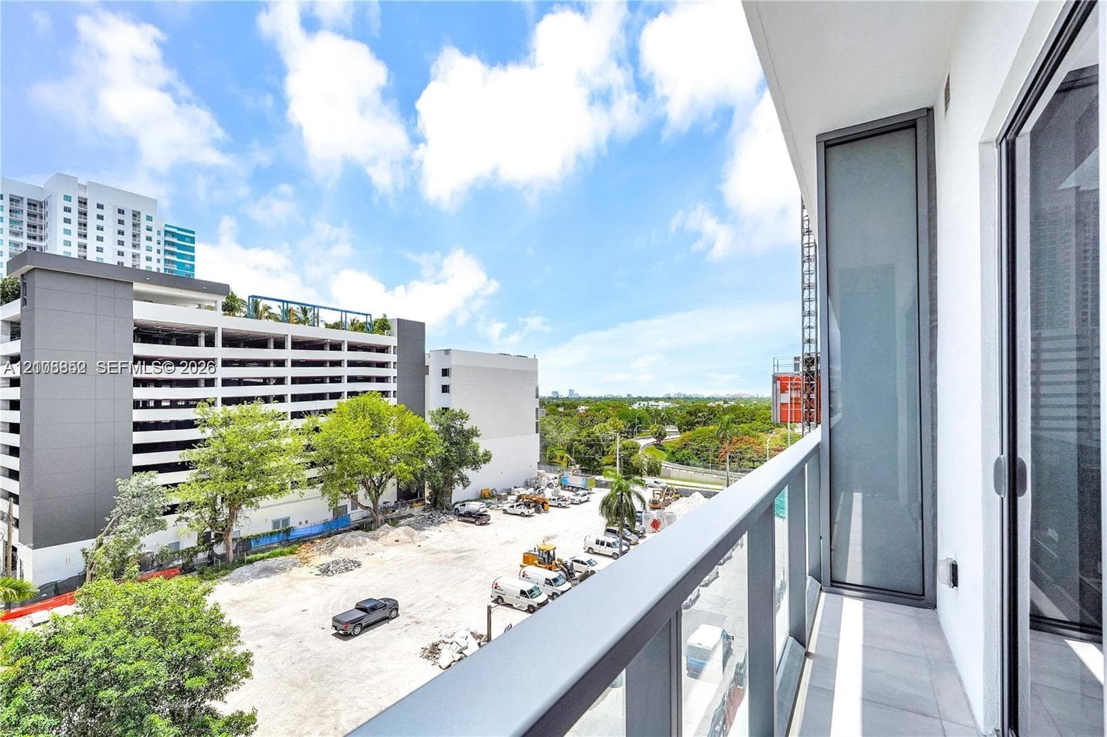 Private balcony featuring concrete flooring, a glass-panel railing, and floor-to-ceiling glass sliding doors