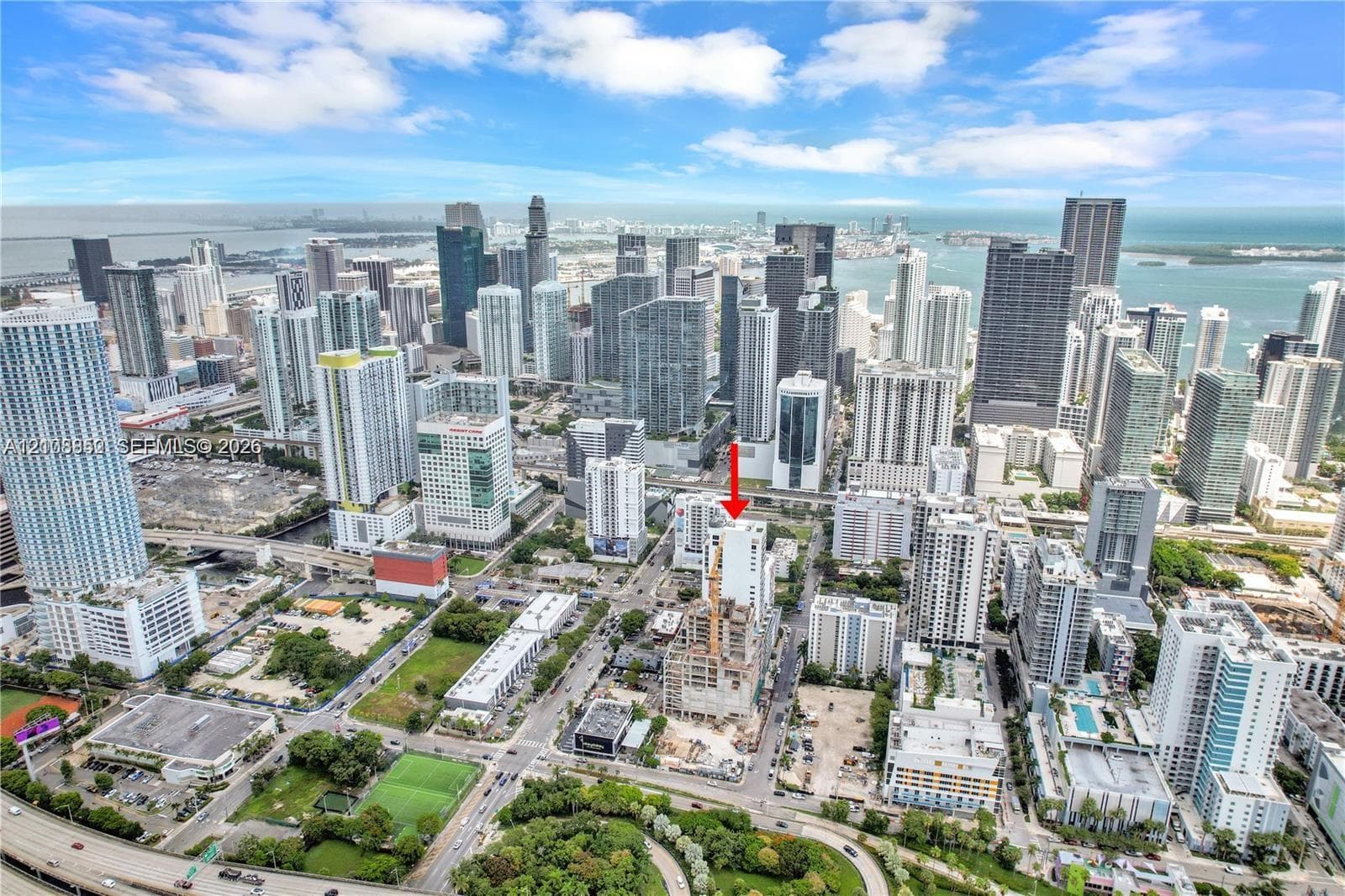 Aerial perspective of a high-rise building featuring a glass and concrete exterior, situated within an urban metropolitan landscape