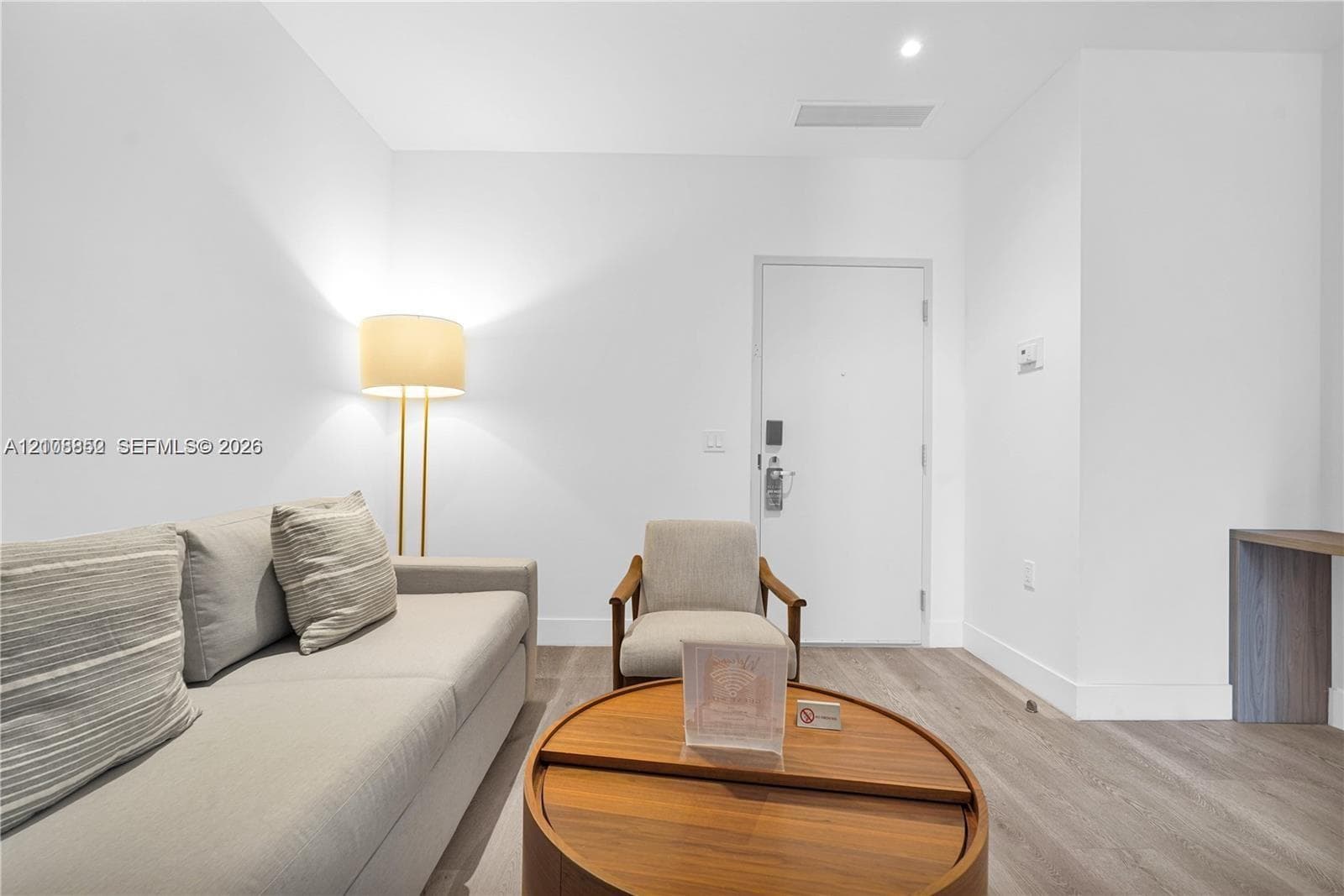 Interior space featuring wood-finish flooring, smooth white walls, and a built-in wood-finish corner desk
