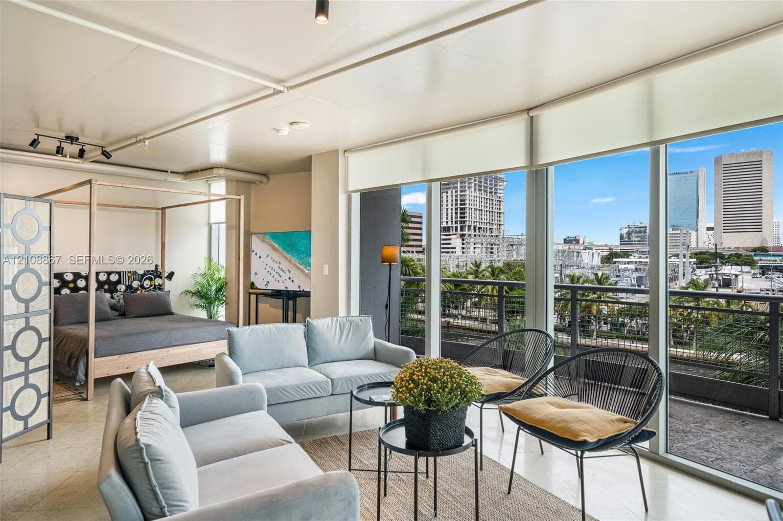 Floor-to-ceiling windows, polished concrete flooring, industrial-style exposed ceiling, and a private balcony featuring a metal railing