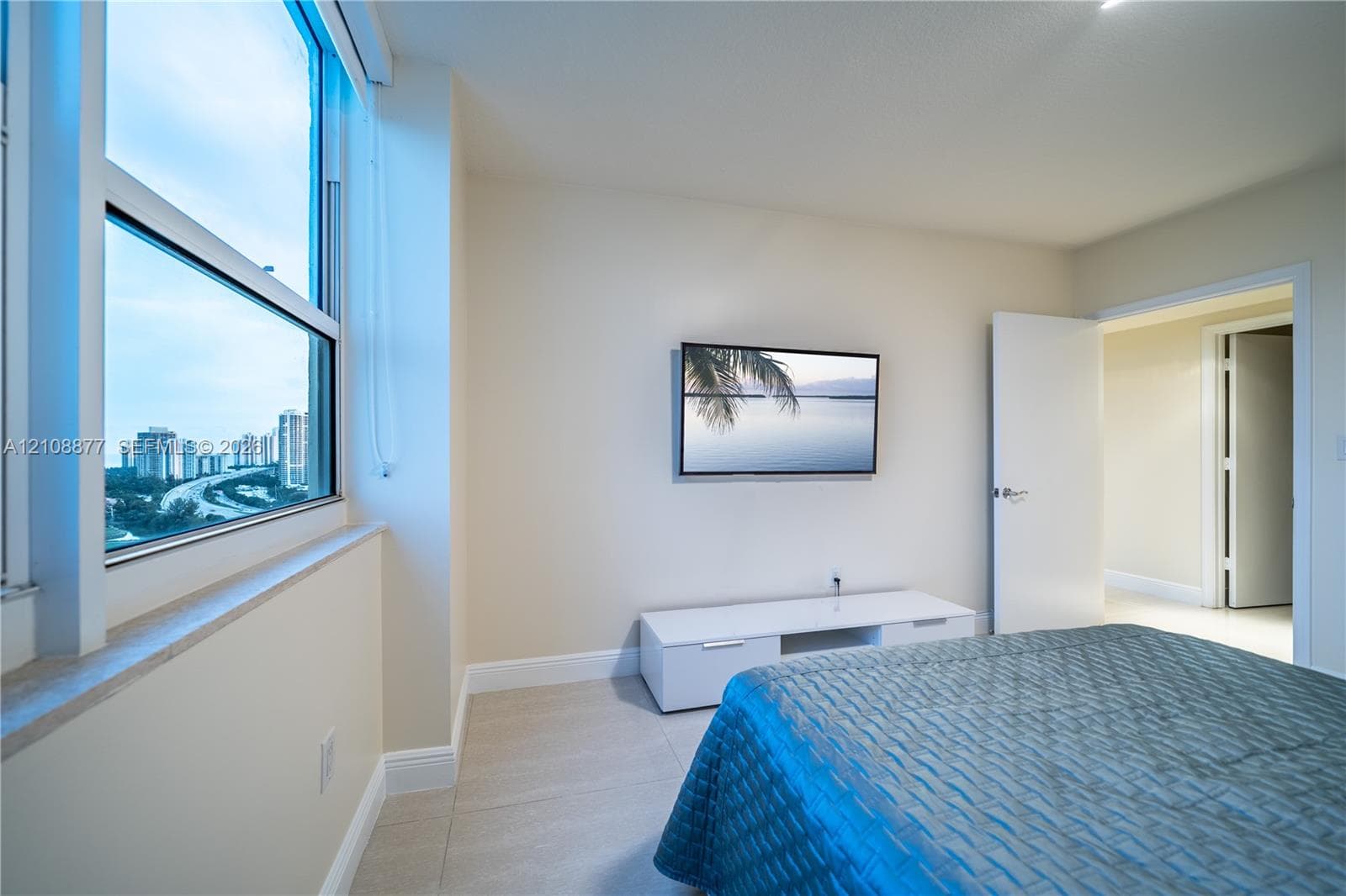 Floor-to-ceiling windows, neutral interior wall color, and large-format tile flooring