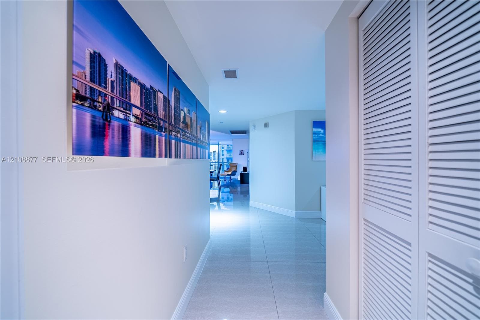 Hallway featuring glossy tile flooring, recessed lighting, and white louvered closet doors