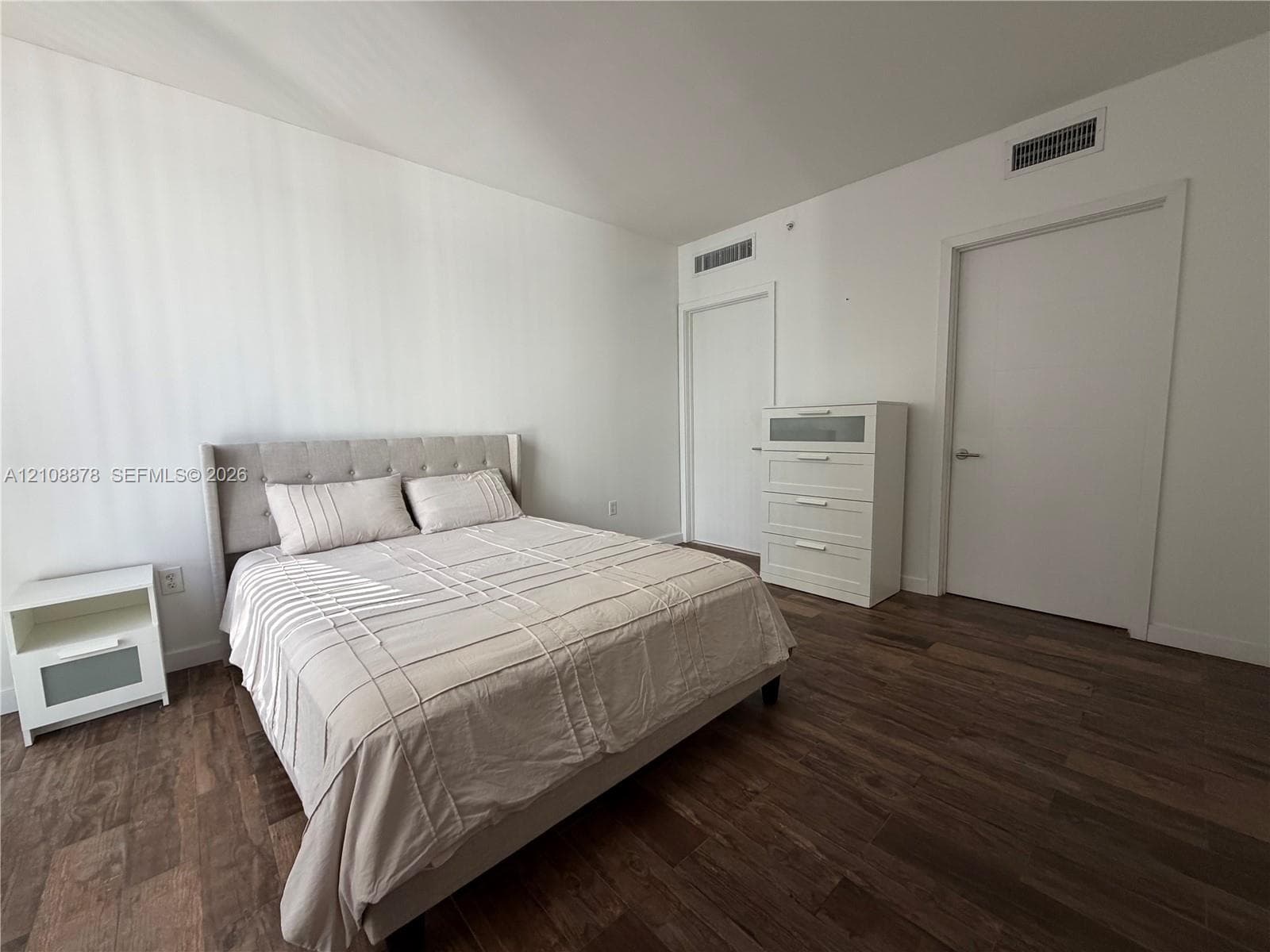 Wood-finish flooring, floor-to-ceiling windows, and access to an exterior balcony