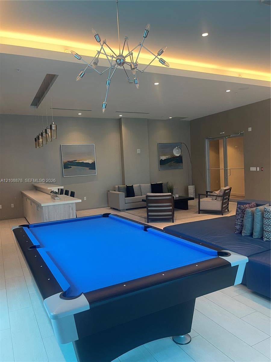Fitness center featuring expansive floor-to-ceiling windows, large-format tile flooring, recessed cove lighting, and floor-to-ceiling wall mirrors