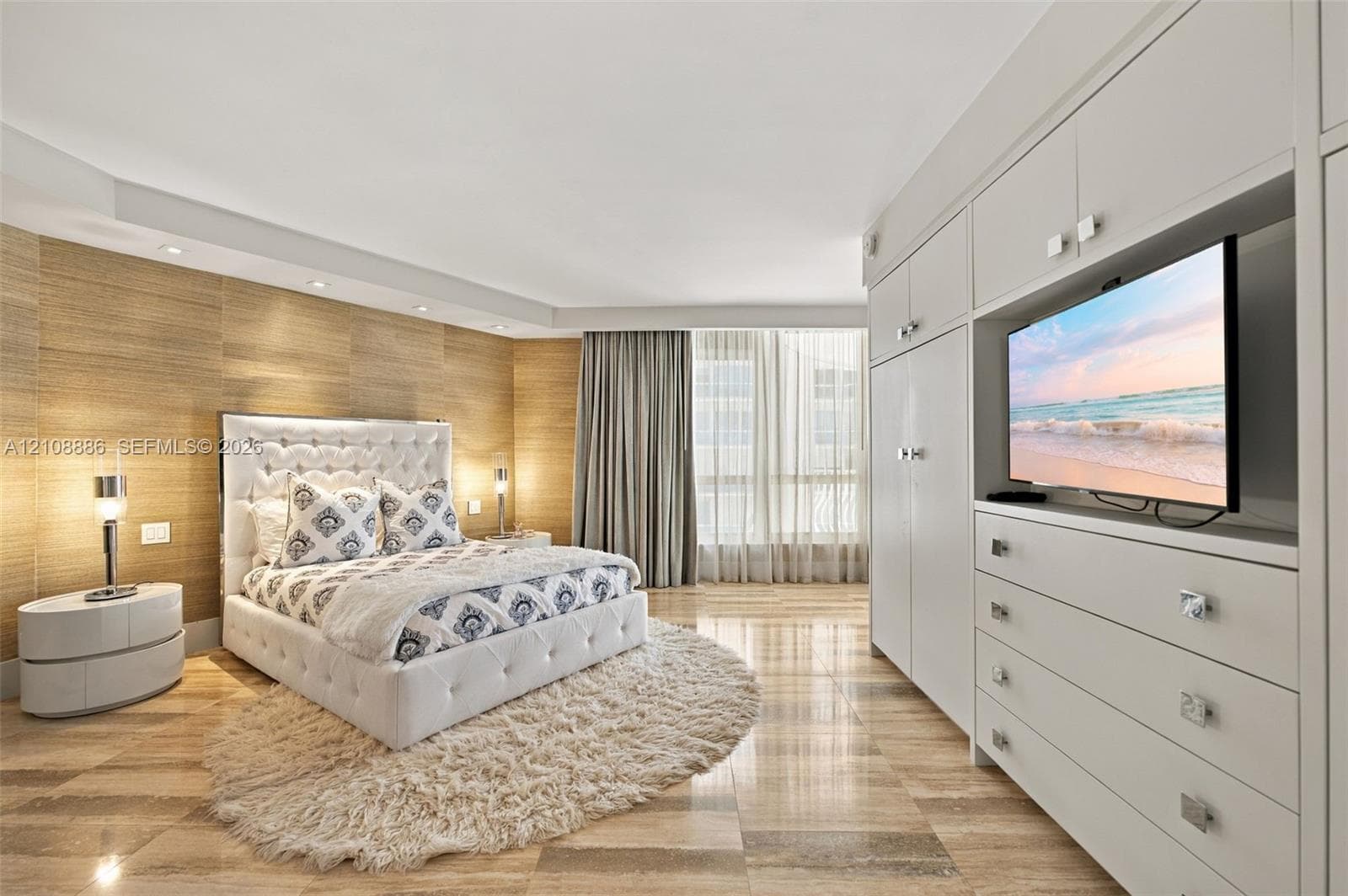 Custom wood-paneled accent wall, stone tile flooring, built-in floor-to-ceiling cabinetry, recessed ceiling lighting, and large window wall