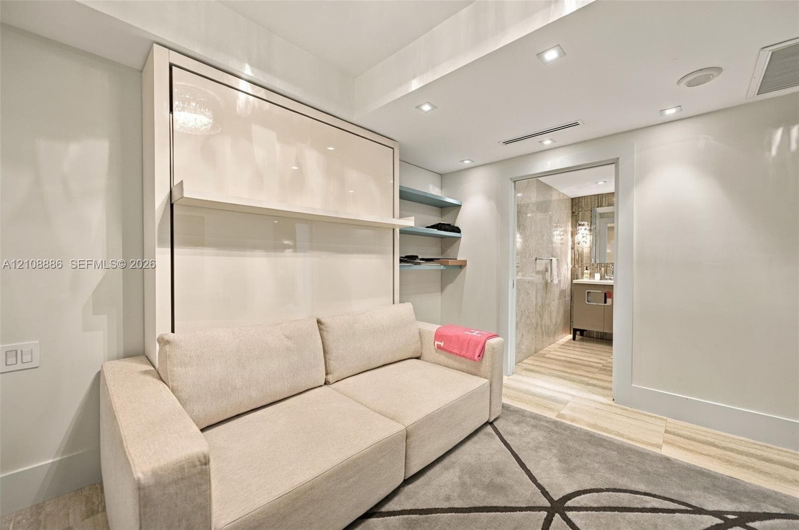 Built-in high-gloss wall cabinetry with integrated shelving, recessed ceiling lighting, and porcelain tile flooring